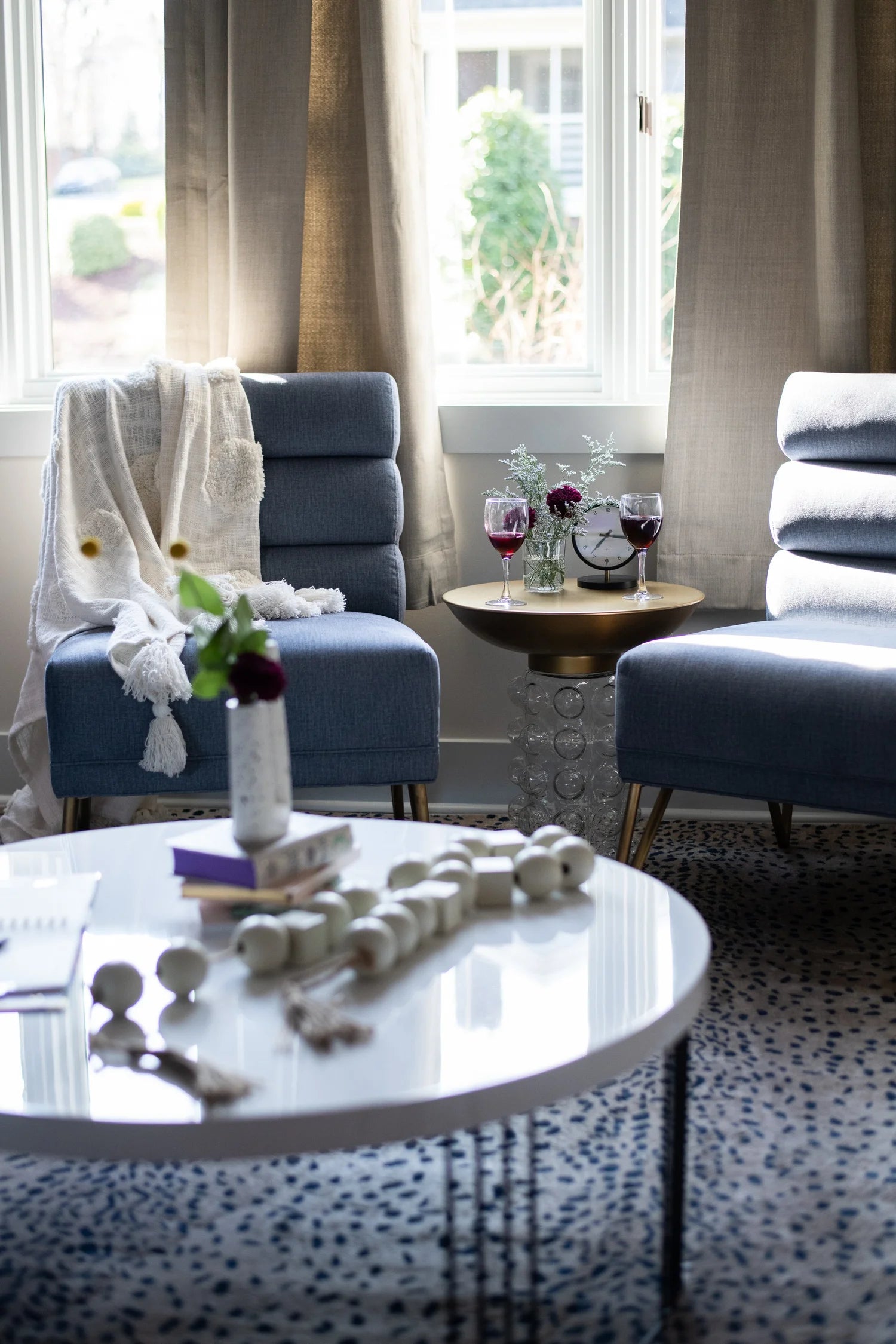 Living room with two blue armchairs, a coffee table, and decorative items.