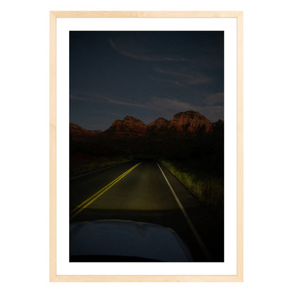 Photograph of a highway and mountains at night in Sedona Arizona framed in natural wood with white mat