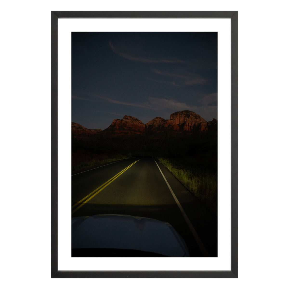 Photograph of a highway and mountains at night in Sedona Arizona framed in black with white mat
