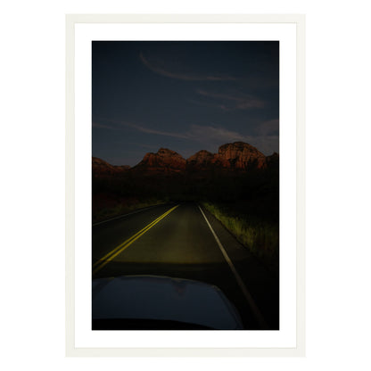 Photograph of a highway and mountains at night in Sedona Arizona framed in white with white mat