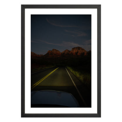 Photograph of a highway and mountains at night in Sedona Arizona framed in black with white mat
