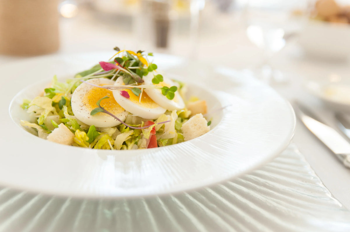 Salad with eggs and vegetables on a white plate